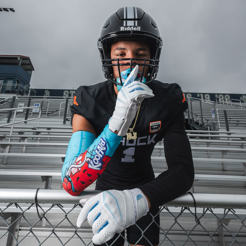 Youth Tackle Football Athlete Wearing  Showtime Kool-Aid Tropical Punch Compression Arm Sleeve and Tropical Punch Flavor Max AirFlow Lip Guard