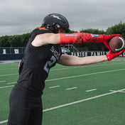 Youth Tackle Football Athlete Catching Football While Wearing Shock Doctor Showtime Kool-Aid Cherry Red Compression Arm Sleeve and Kool-Aid Cherry Flavor Gel Max Power Mouthguard