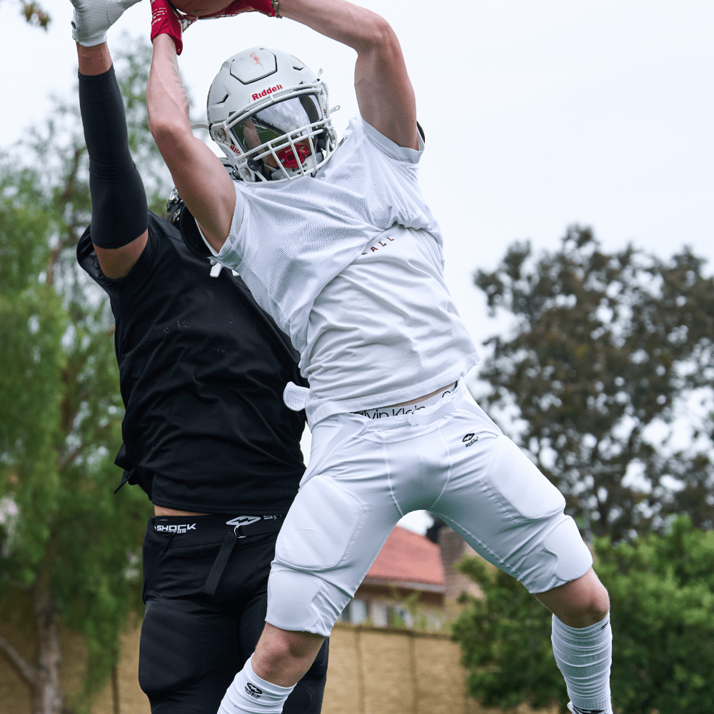 Lifestyle Image of Youth Tackle Football Receiver Wearing Shock Doctor Showtime Football Integrated Pant (White)