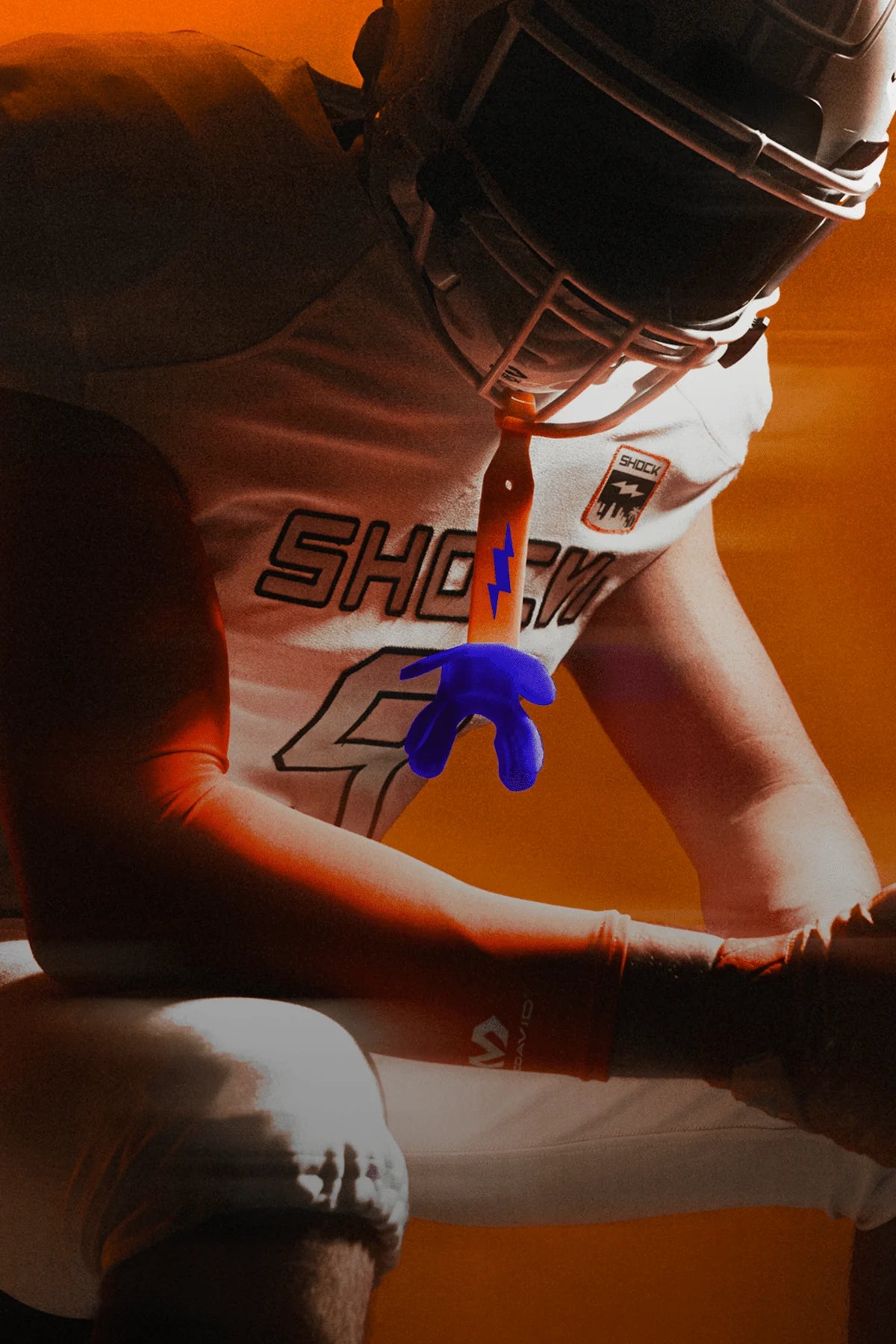 Person wearing a helmet and protective lip guard against an orange background