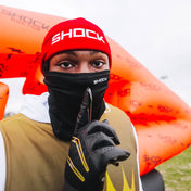 7v7 football athlete wearing a red 'SHOCK' beanie and black/gold gloves with an orange "shock doctor" inflatable in the background. Also, wearing Black "Sheisty" Ski Mask