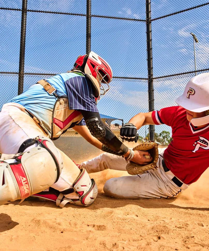 Baseball Player Sliding into Plate with a Catcher Trying to Tag Him Out