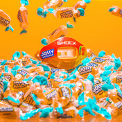 Lifestyle Shot of Shock Doctor Jolly Rancher Max AirFlow Football Mouthguard (Mango Flavor) Sitting on Bed of Jolly Ranchers