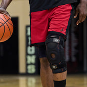 Athlete Wearing Shock Doctor Ultra Knee Support with Bilateral Hinges While Paying Pick Up Basketball