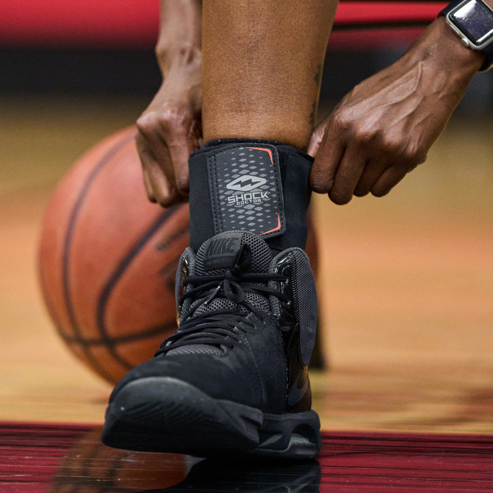 Athlete  Pulling Up Shock Doctor Ultra Wrap Lace Ankle Support Over Ankle for Better Fit