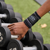 Athlete Wearing Shock Doctor Compression Knit Wrist Sleeve with Strap While Lifting Dumbbells