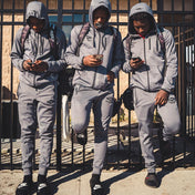 3 Youth Football Players Leaning Against a Fence Wearing Shock Doctor Athletic Zip-Up Hoodie in Grey