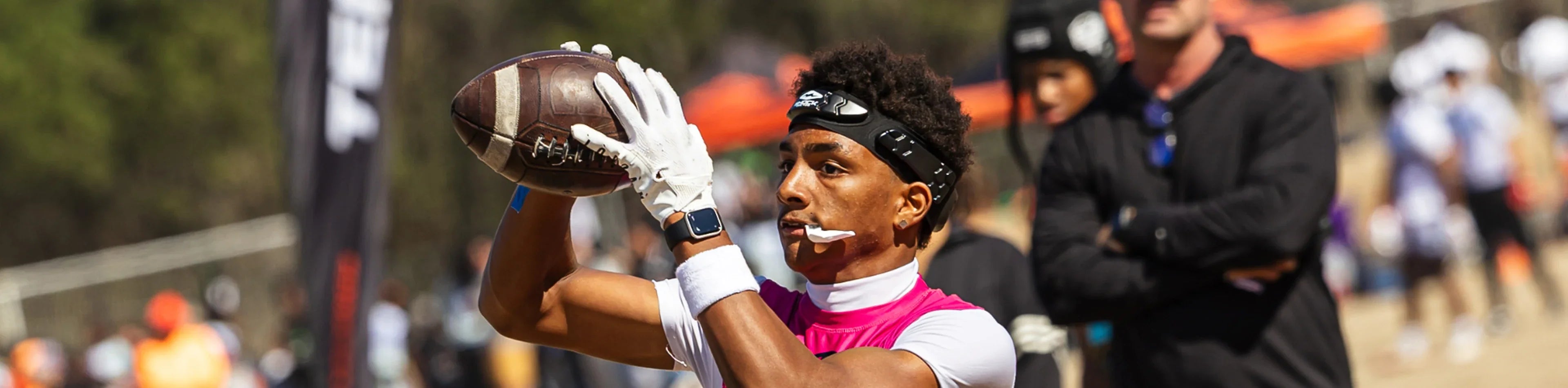 Football player wearing a black Shock Doctor headband while catching a pass