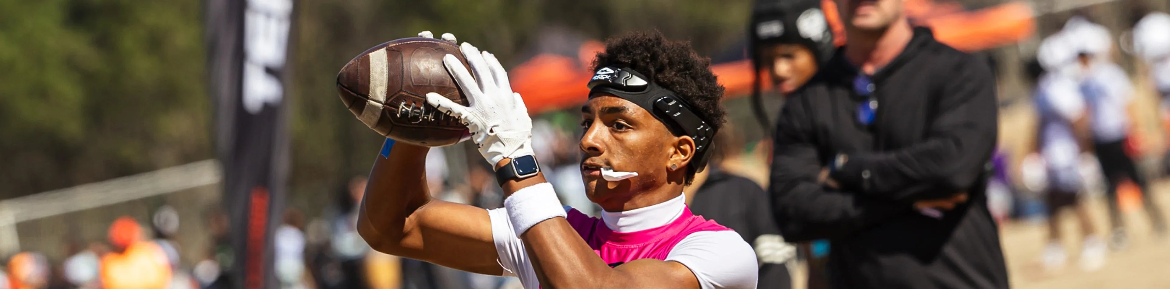Football player wearing a black Shock Doctor headband while catching a pass