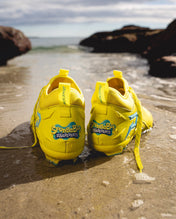 SpongeBob Quantum Speed 2.0 cleats by Phenom Elite in shallow surf, heel view of SpongeBob SquarePants logos