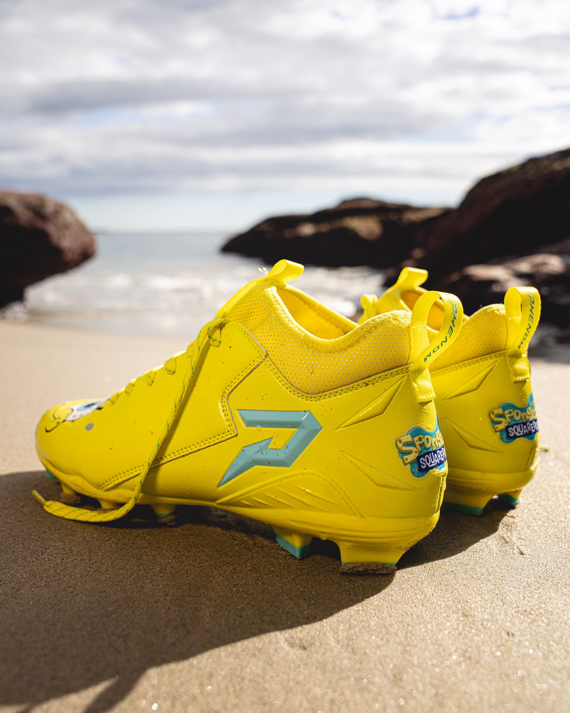 SpongeBob Quantum Speed 2.0 cleats by Phenom Elite on a beach, side and heel view with teal P logo and SpongeBob heel logo