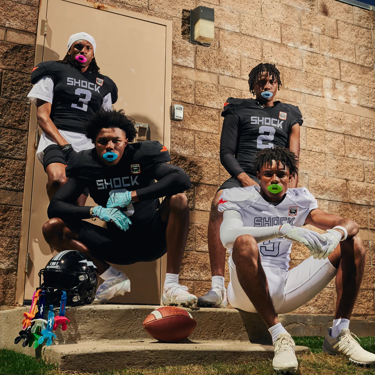 Four football players wearing Shock Doctor lip guards pose together in football gear.