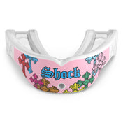 Front view of the Shock Doctor Gel Max Power Print mouthguard in Pink Divine Drip. Pink and white mouthguard featuring multicolored gothic crosses in red, blue, green, orange, and yellow wrapping the front, with "Shock" in blue Old English lettering and a center breathing hole.