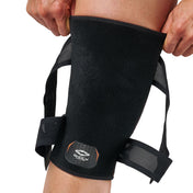 Person pulling the top edge of the Shock Doctor Cross Compression Knee Sleeve into place on their leg, with the unfastened straps hanging loose on either side