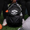 Shock Doctor Premium Backpack - Lifestyle Image 3 - Youth 7v7 Football Player Holding Backpack By Top Hang Strap