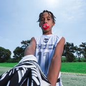 Youth football player in white Shock Doctor uniform wearing a red Shock Doctor Max AirFlow Lip Guard while standing on the field.