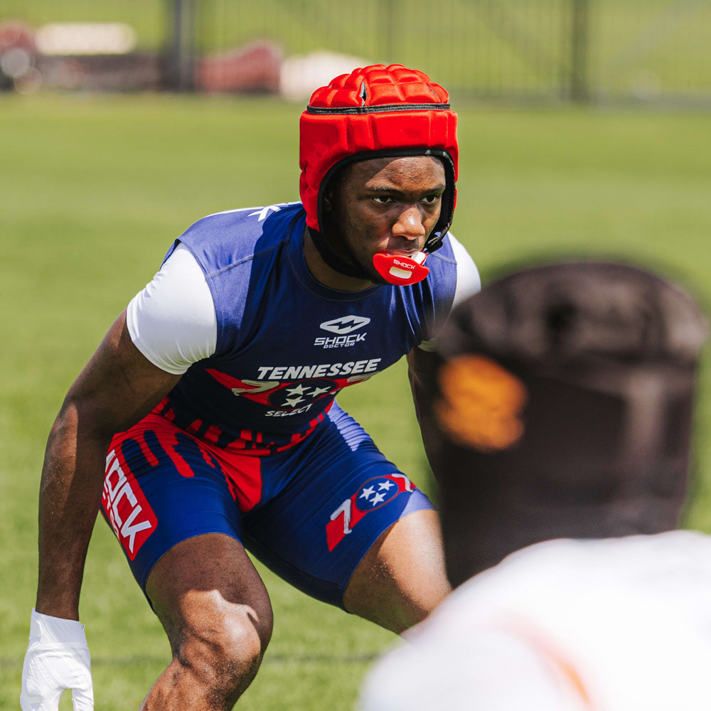 Football player in blue and red Tennessee uniform wearing a red Shock Doctor Max AirFlow Lip Guard and padded headgear on the field.