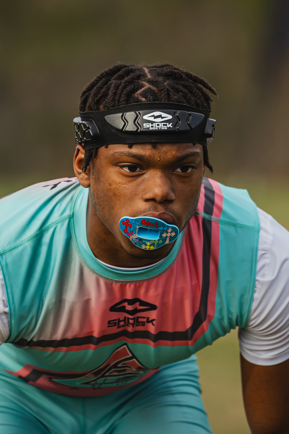 7v7 football athlete wearing a lip guard &  colorful sports outfit with a blurred background
