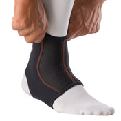 Person pulling on the Shock Doctor Ankle Sleeve, showing the stretch fit and easy on/off design