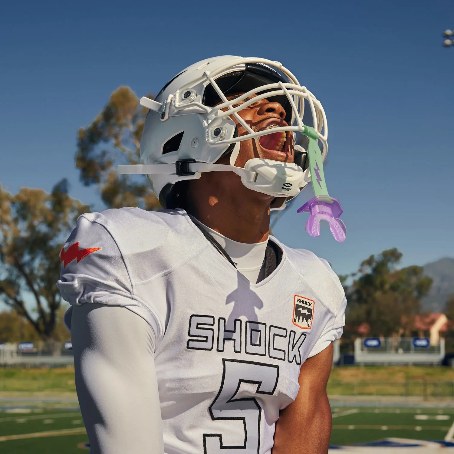 Person wearing a football uniform with 'Shock' on a sports field