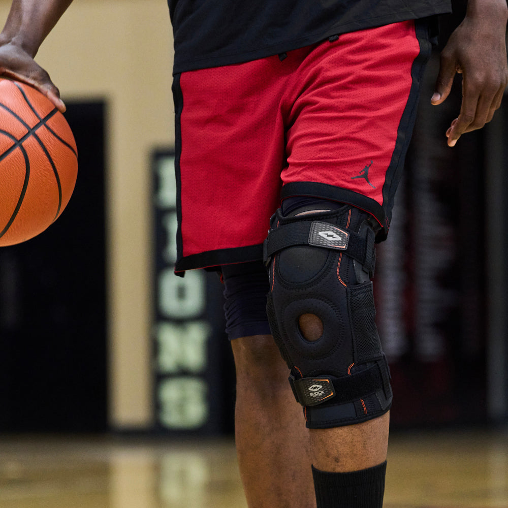 Athlete Wearing Shock Doctor Ultra Knee Support with Bilateral Hinges While Paying Pick Up Basketball