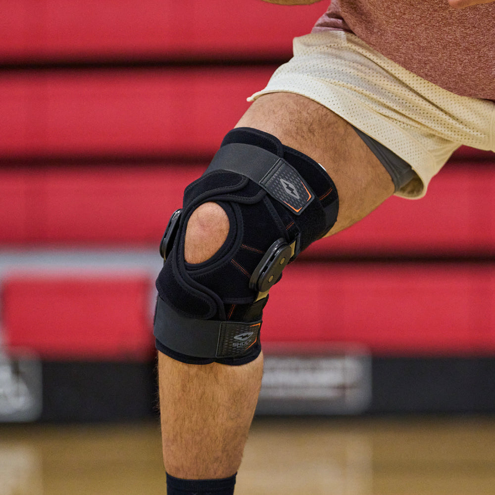Athlete Wearing Shock Doctor Knee Brace with Dual Wrap & Heavy-Duty Hinges on Court