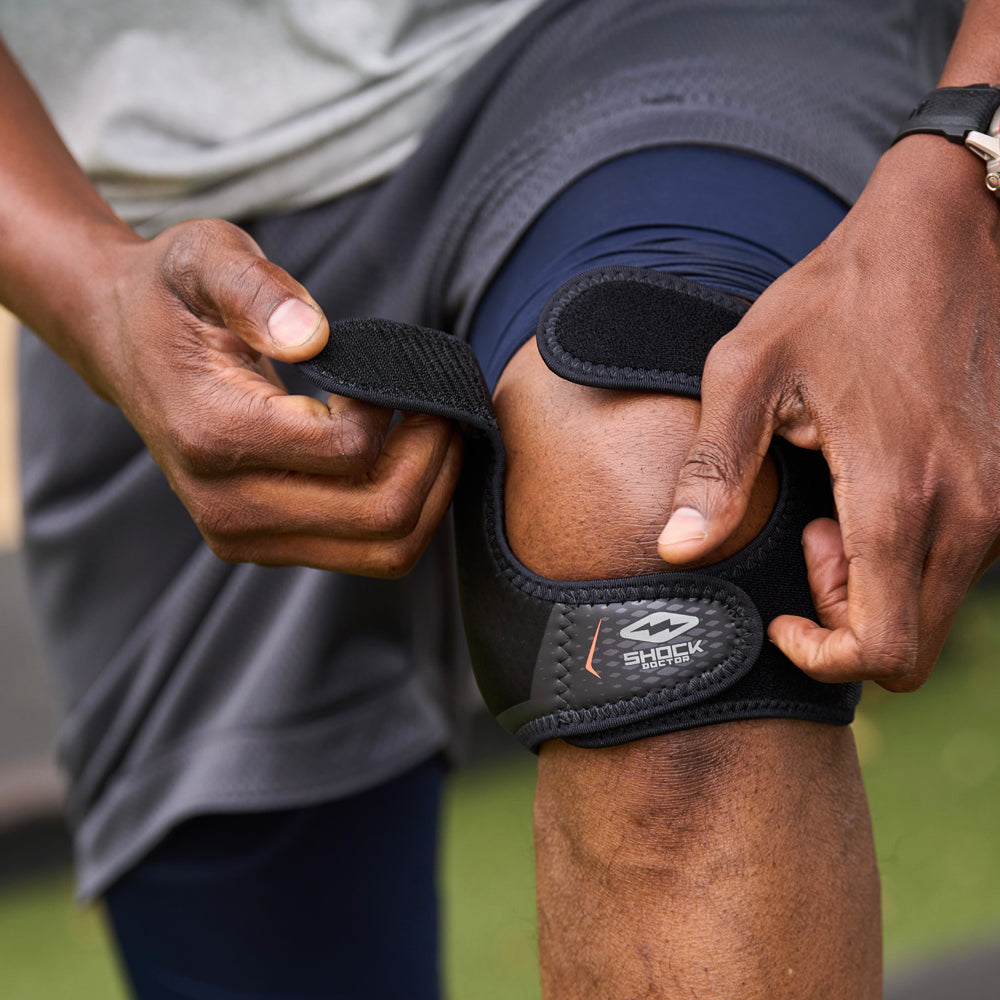 Athlete Strapping On Shock Doctor Dual Strap Knee Wrap