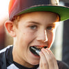 Lifestyle Image of Youth Baseball Player Fitting the Shock Doctor Fang Double Braces Mouthguard 