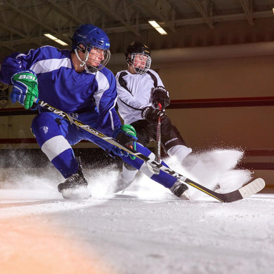 Lifestyle Shot of Hockey Players Battling Over Puck Wearing Shock Doctor Compression Shorts Under their Uniform