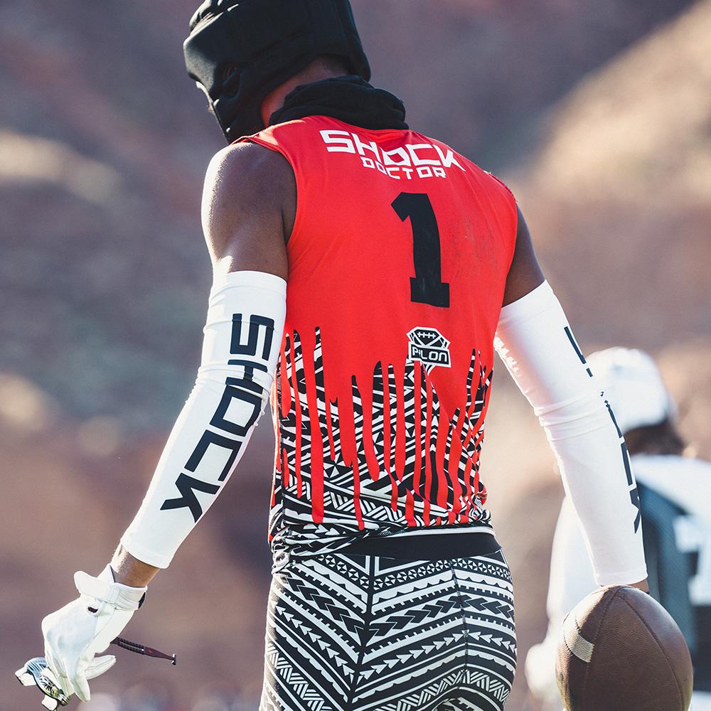 Youth 7v7 Football Player Wearing White Shock Doctor Compression Arm Sleeve