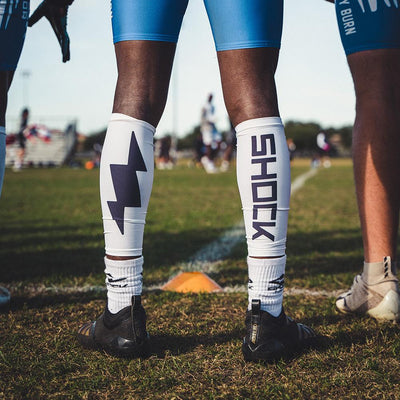 Lifestyle Shot of Youth 7v7 Football Player Wearing Shock Doctor Shock Doctor Compression Calf Sleeves - White